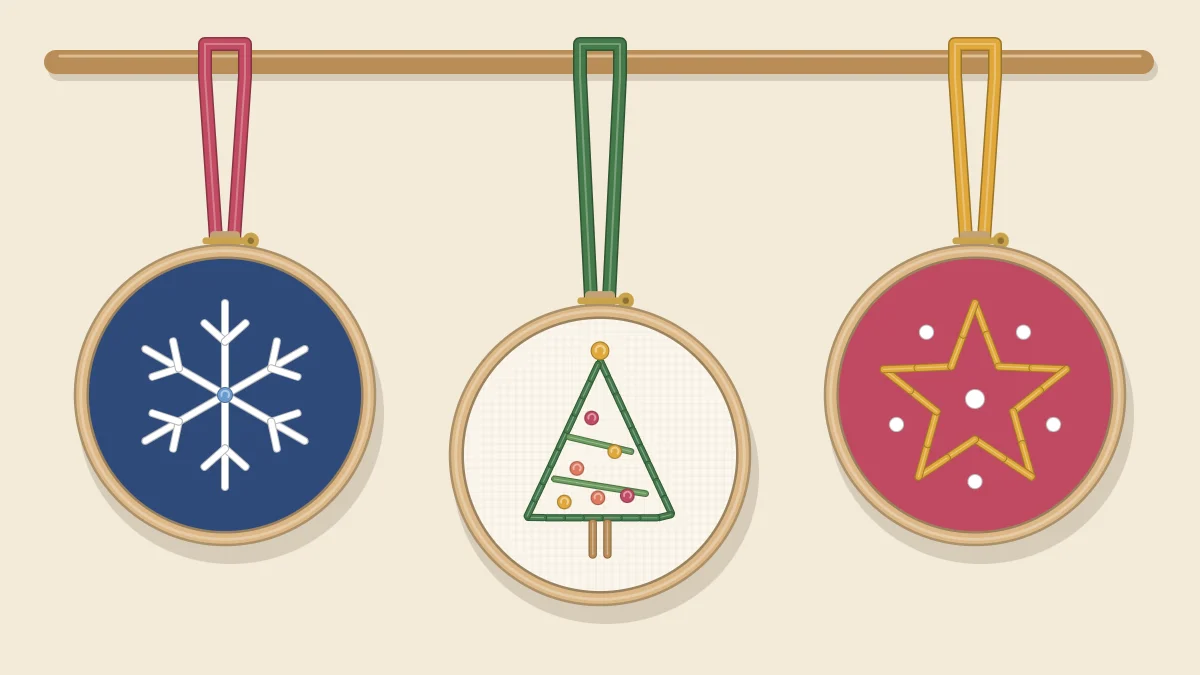 Three mini embroidery hoops hanging from ribbon loops, one with a snowflake, one with a Christmas tree and one with a star
