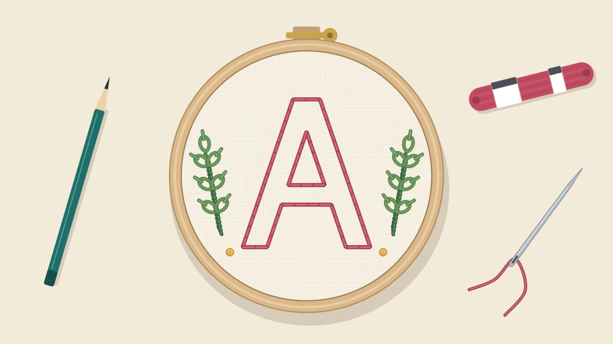 Embroidery hoop with a large letter A outlined in backstitch and small leafy sprigs on either side