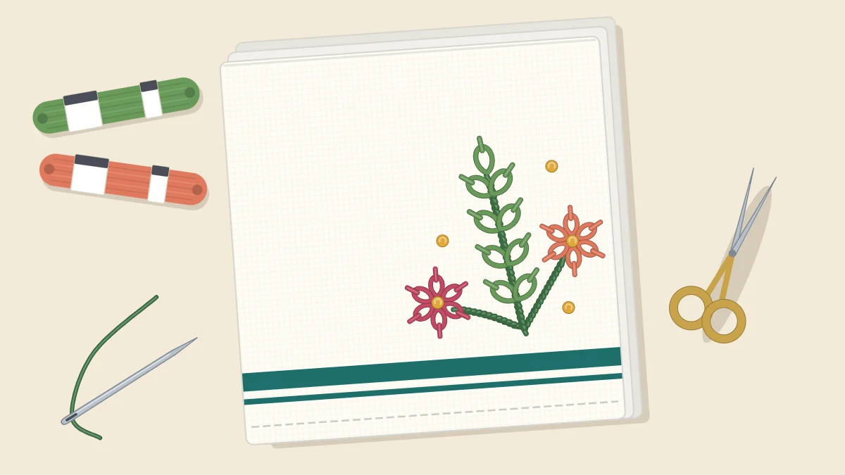 Folded tea towel with a stripe near the hem and a small embroidered leafy sprig with flowers in the lower corner