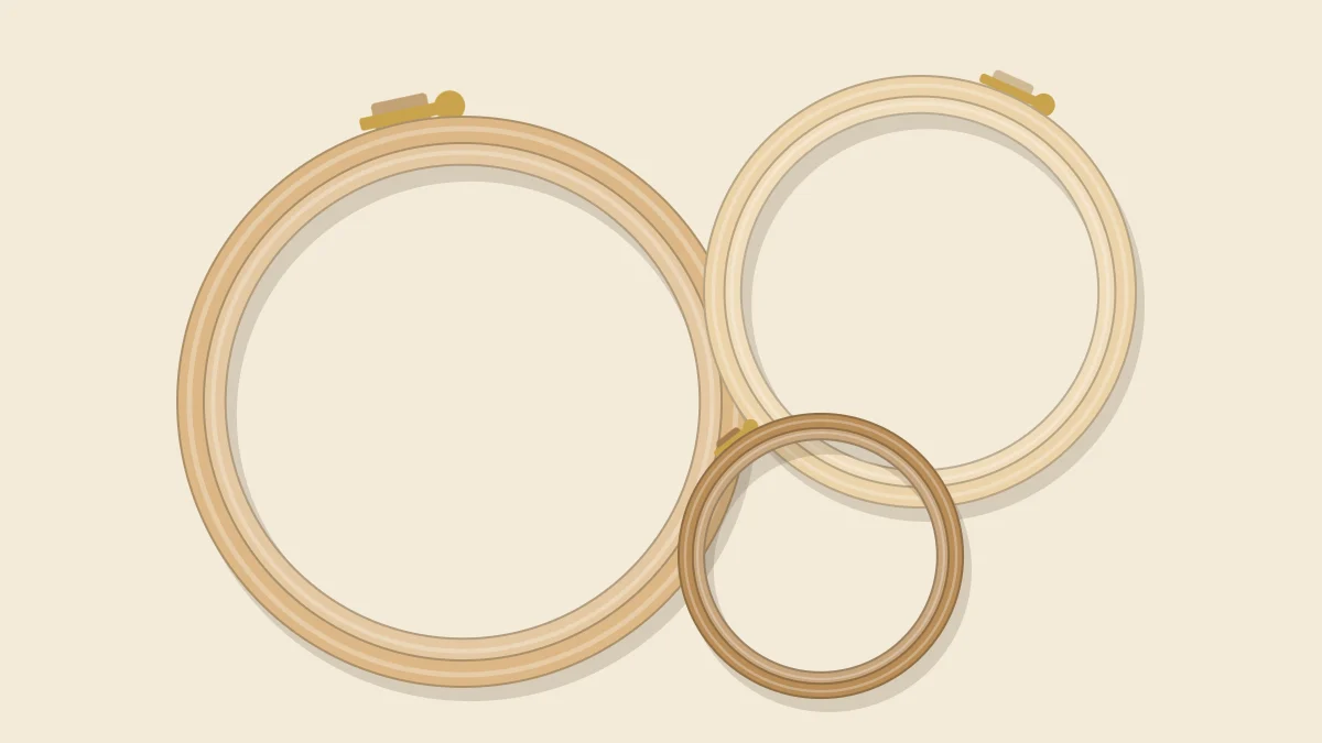 Three empty wooden embroidery hoops of different sizes overlapping each other