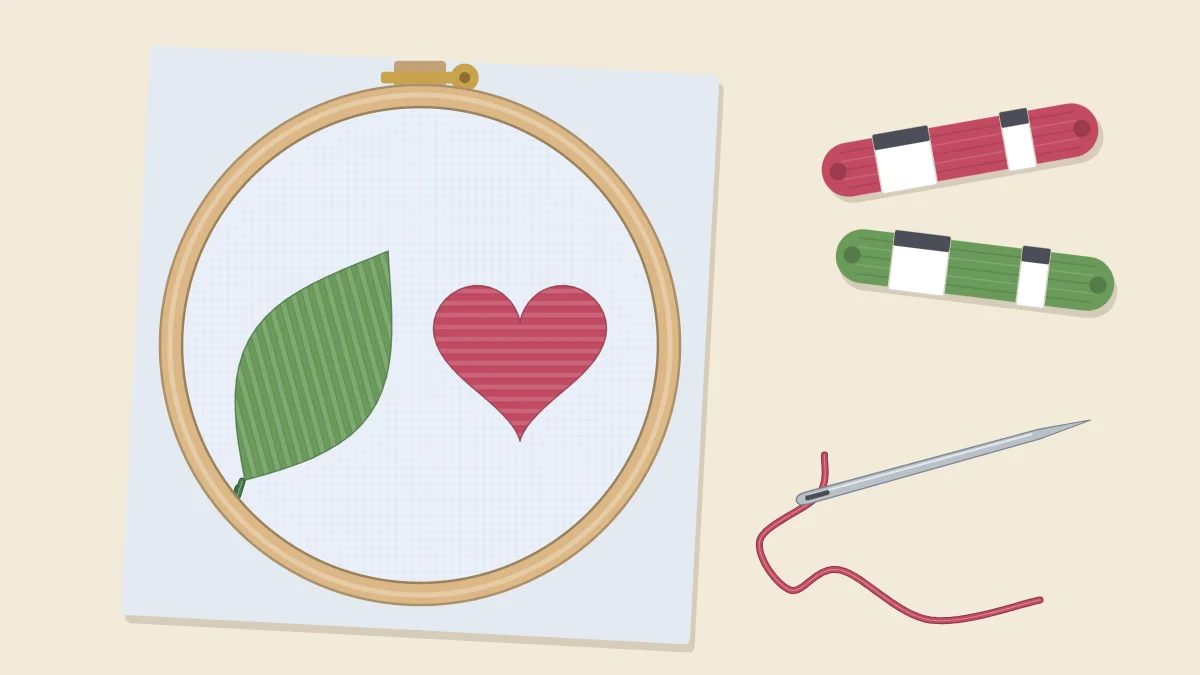 Embroidery hoop with a leaf and a heart filled in satin stitch